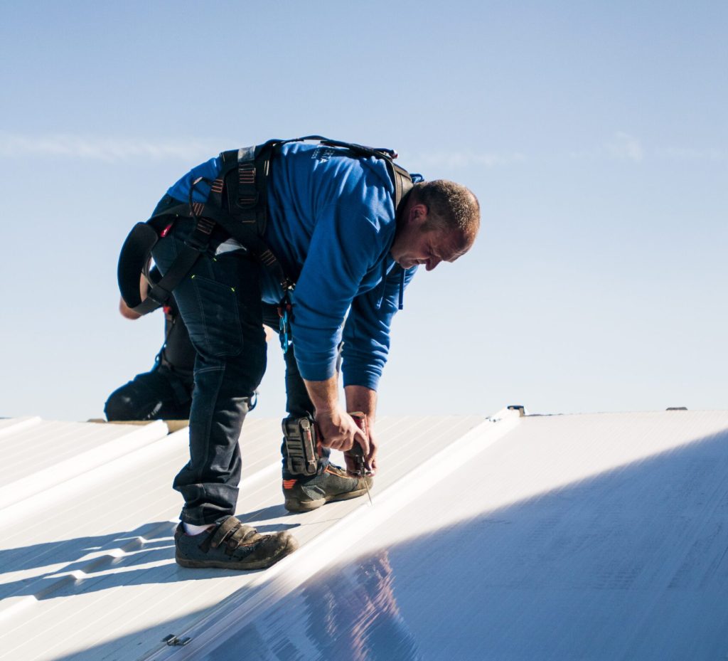 Trabajador instalando cubiertas en un techo de un edificio